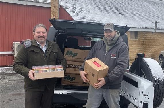 MRAA Director of Communications Steve Harmic, left, receives a donation of food items to benefit the Meals on Wheels and More program from Country Butcher owner Jason Gill, right.