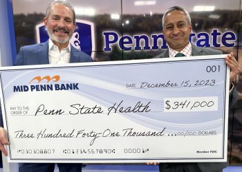  Rory Ritrievi, president and CEO of Mid Penn Bank (at left), and Dr. Jay Raman, interim chair of the Department of Urology at the Milton S. Hershey Medical Center, pose with an oversized check representing the amount raised in their 2023 "No Shave November" effort.
