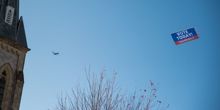 A VotesPA.com banner is flown behind a plane over downtown Erie on Election Day 2022.

Robert Frank / For Spotlight PA