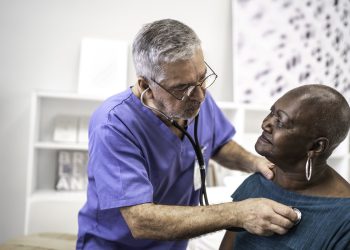 Doctor using a stethoscope listen to the heartbeat of the elderly patient