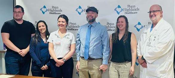 It was a happy reunion at Penn Highlands DuBois among patient Timothy Richmond and the trauma team and first responders who saved his life following a recent industrial accident. Shown (l. to r.) are Matthew Wachob, Emergency Medical Technician with Clearfield EMS; Katie Anthony, Trauma Performance Improvement Coordinator for Penn Highlands DuBois; Holly Hertlein, BSN, RN, CEN, Trauma Program Manager for Penn Highlands DuBois; Timothy Richmond; Kelly Richmond; and Philip S. Vuocolo, MD, MHA, FACS, a board-certified acute-care and trauma surgeon at Penn Highlands General Surgery and Trauma Medical Director for Penn Highlands DuBois.