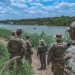 Soldiers from the Texas National Guard watch a Border Patrol helicopter hover above a group of civilians wading in the Rio Grande River along the Texas-Mexico border, May 22, 2023. The Soldiers patrol the southern border in support of Operation Lone Star to detect, deter, and interdict illegal immigrants before they enter Texas communities.

Pvt. Steven Day | Texas National Guard