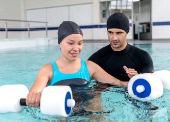 Young woman doing physical therapy in the water - healthcare and medicine