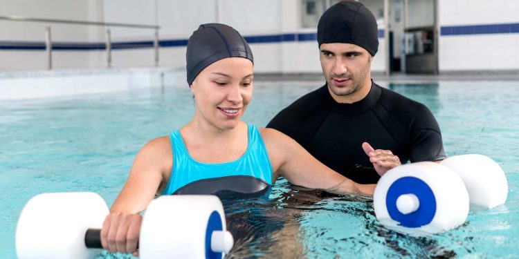 Young woman doing physical therapy in the water - healthcare and medicine