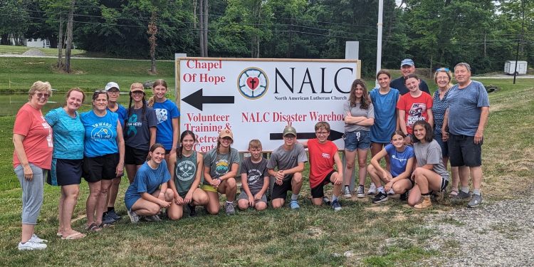 The members of the Christ Lutheran Church mission group are shown at the sign for the North American Lutheran Church (NALC) Disaster Response Warehouse and Retreat Center, Caldwell, Ohio. 
In the back row, from left, are: Mary Bates, Penny Prontock, Debbie Finalle, Pastor Amy Godshall-Miller, Hannah Fontaine, Tristin Fontaine, Grace Prontock, Madysn Sedor, Pastor John Miller, Addy Armagost, Charmaine Dungey and Jim Dungey. 
In front, from left, are: Marley Hemke, Avery Fontaine, Kamryn Fontaine, Ansen Armagost, Calix Myers, Drew London, Alexis Gibson and Virginia Myers.