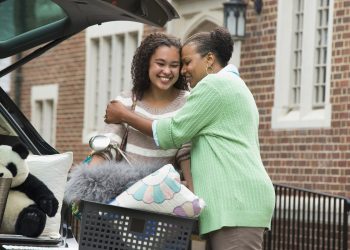 Mother and daughter hugging near car