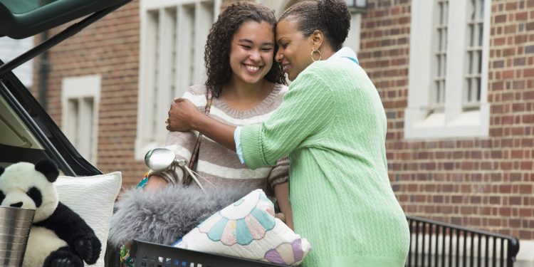 Mother and daughter hugging near car