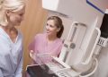 Nurse Assisting Older Patient About To Have A Mammogram In Hospital Room