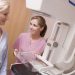 Nurse Assisting Older Patient About To Have A Mammogram In Hospital Room